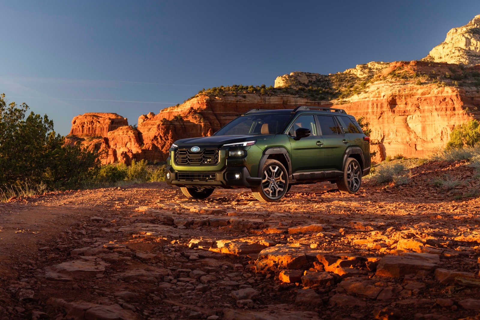 Green 2027 Subaru Outback parked on red rock terrain
